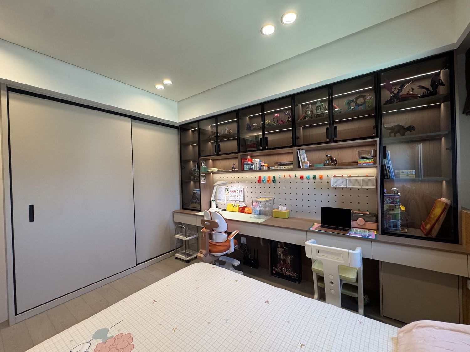 桃園楊梅案場：兒童房全景，白色滑門衣櫃、鋁框玻璃展示櫃與書桌區